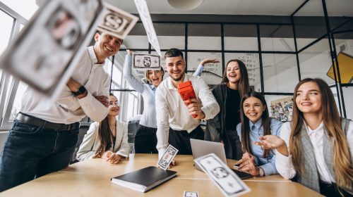 Group of people throwing money in an office